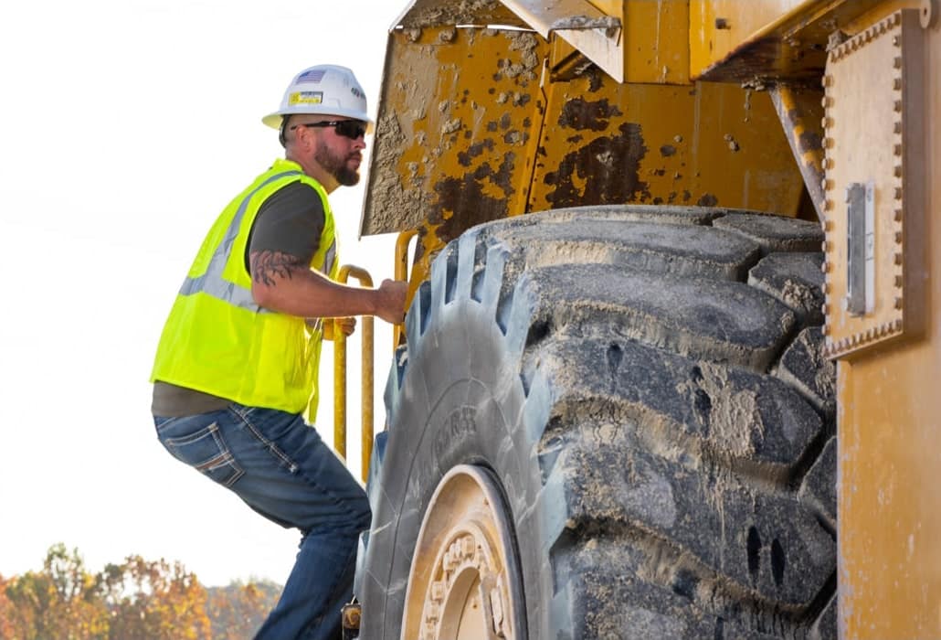 Sand plant worker climbing into a loader